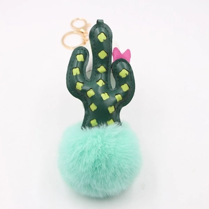 Green leather cactus keychain with mint green pompom and pink bow on white background