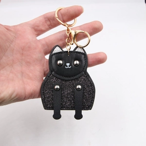 Detail of black cat keychain featuring glitter finish and silver stud eyes in gold hardware