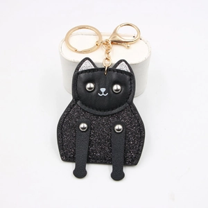 Cute black leather cat keychain with glitter body and gold hardware on a white stand