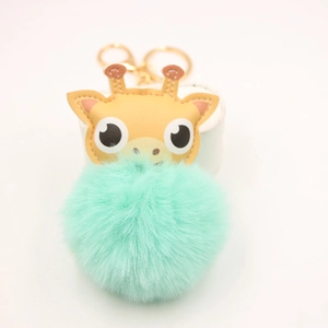 Détail du porte-clés girafe avec pompon vert menthe et anneau métallique doré