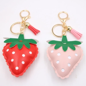 Red and pink strawberry leather keychains with golden clasps and matching tassels