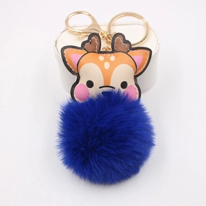 Detail of cute reindeer plush pom-pom keychain with golden lobster clasp on white pedestal