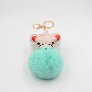 Detail view of pink bear leather charm and mint green faux fur pompom for keychain