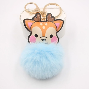 Close-up of cute reindeer plush keychain with light blue faux fur pompom and gold clip