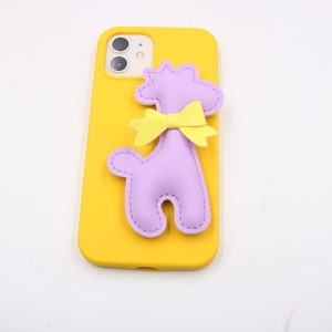 Detailed close-up of yellow phone case with purple leather giraffe and bow charm