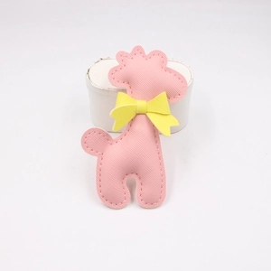 Detailed close-up of pink giraffe PU leather charm with yellow bow and cross pattern texture