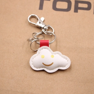 Detailansicht weißer Leder-Wolken-Schlüsselanhänger mit Gold-Smiley und Silberring