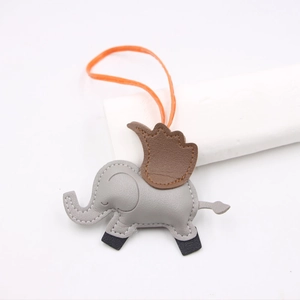 Détail d'un pendentif éléphant en cuir avec texture litchi et cordon orange