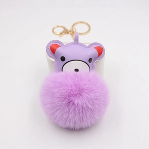 Detailed view of purple plush ball keychain with a cute leather bear head and gold clasp