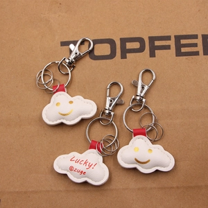 Detailansicht der wolkenförmigen Lederanhänger mit Lucky-Stickerei und silbernen Ringen