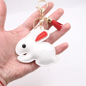 White rabbit leather keychain with red ears and tassel on a gold metal clasp