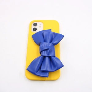 Close-up of vibrant yellow phone case with a large blue PU leather bow accessory