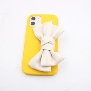 Bright yellow silicone phone case with a large cream 3D PU leather bow decoration