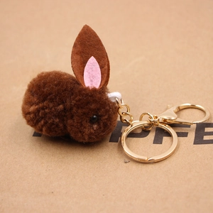 Détail d'un porte-clés lapin en peluche marron avec fermoir doré et oreilles roses