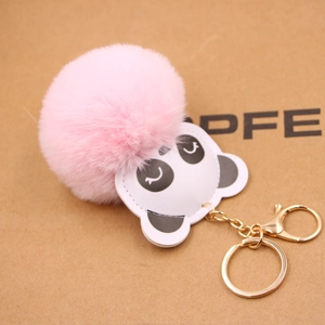 Detail eines rosa Pelzimitat-Pompom-Schlüsselanhängers mit Panda und Goldbeschlägen