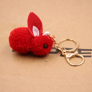 Gros plan du porte-clés peluche lapin rouge avec anneau doré et oreilles en feutre
