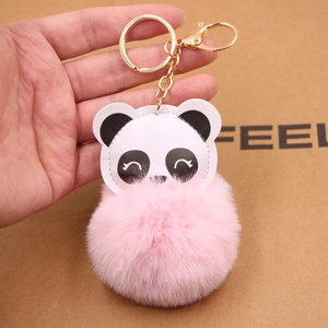 Detail eines niedlichen Panda-Plüsch-Schlüsselanhängers mit rosa Fellkugel und Goldclip