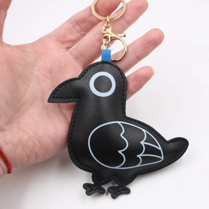 Handcrafted black leather pigeon bird charm keychain with golden hardware and blue accents