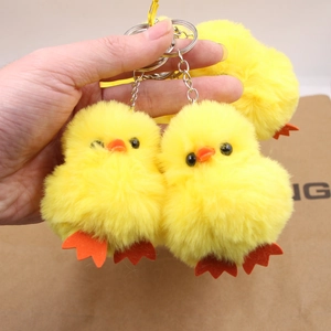 Détail de porte-clés poussin en peluche jaune montrant la texture douce et l'anneau