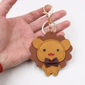 Porte-clés lion en cuir fait main avec fermoir doré et nœud brun sur fond blanc neutre