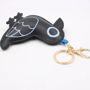 Minimalist black bird leather keychain with golden metal ring and blue strap on white background