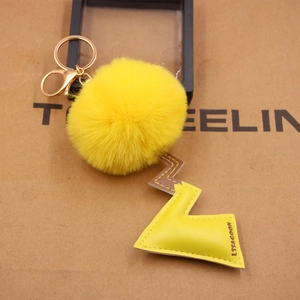 Plush yellow pom-pom keychain with leather lightning tail and gold metal lobster clasp