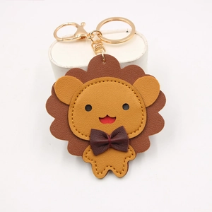 Porte-clés lion en cuir avec mousqueton doré et nœud papillon sur support blanc