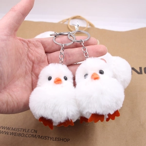 Gros plan de deux porte-clés poussins en peluche blanche avec bec orange et anneau métal