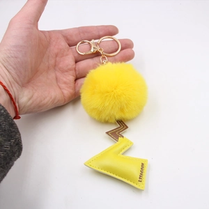 Cartoon plush ball keychain featuring yellow lightning leather pendant and gold hardware
