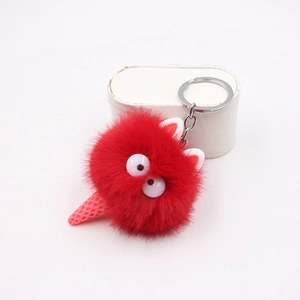 Dettaglio del portachiavi mostro di peluche rosso con base a forma di cono rosa