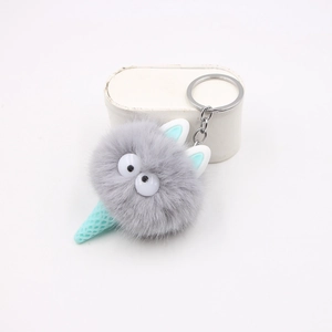 Dettaglio di un ciondolo creativo in peluche a cono gelato con pompon grigio e anello in metallo