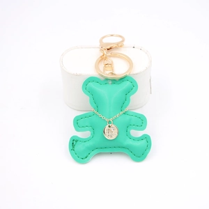 Detail of mint green leather bear keychain with golden ring and zircon charm