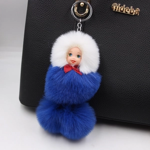 Close-up of a blue plush snowman doll keychain with fluffy fur balls on a black bag