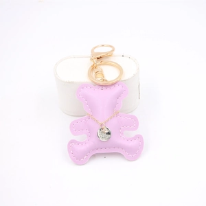 Detail of light purple leather bear keychain with golden necklace and lobster clasp