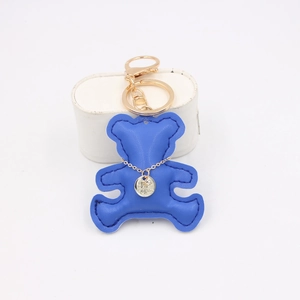 Detail view of royal blue faux leather bear keychain with golden alloy ring and mini pendant