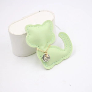Detail showing high-quality light green leather cat charm with it's me metal tag
