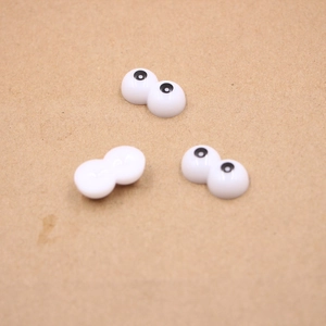 Detailed view of plastic googly eyes with a flat back design for DIY doll making and crafts