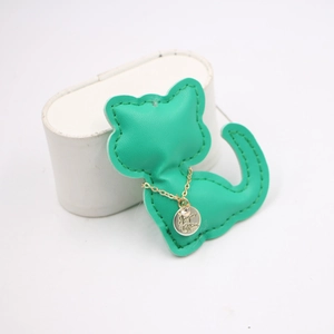 Close-up of golden necklace with engraved rhinestone pendant on green cat-shaped leather pad