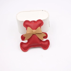 Cute red leather bear keychain pendant with tan bow and decorative red stitching detail