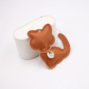 Detailed view of a handmade brown leather cat pendant with fine stitching and gold chain