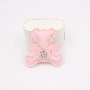 Golden pendant necklace with crystal on pink leather bear charm display holder