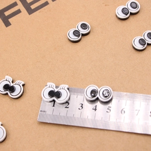 Cartoon resin toy eyes with lashes and round pupils on kraft paper with ruler