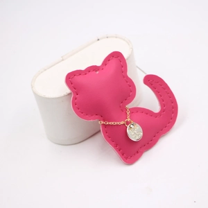 Detail showing the rose red leather cat pendant with gold chain and rhinestone charm