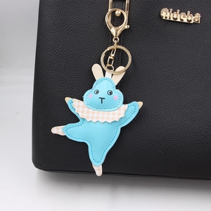 Détail d'un porte-clés lapin de ballet bleu clair avec oreilles à carreaux sur un sac en cuir