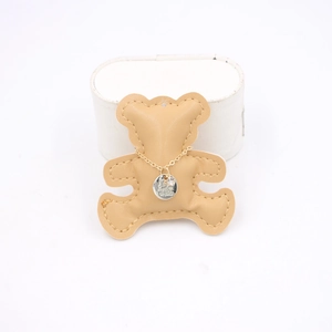 Gold necklace with engraved love pendant on a brown bear leather card display