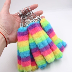 Rainbow faux fur tail keychain with silver metal spring ring on a white background