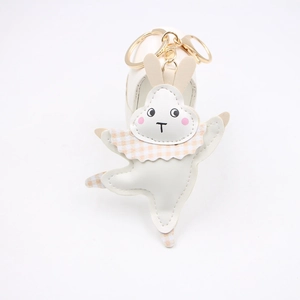 Détail du porte-clés lapin en cuir blanc avec col à carreaux orange et fermoir mousqueton doré