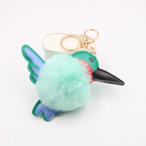 Macro view of mint green hummingbird plush keychain with leather wings and gold clasp