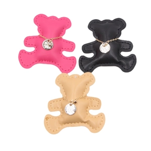 Three leather bear charms in rose red, black, and beige with gold chain details