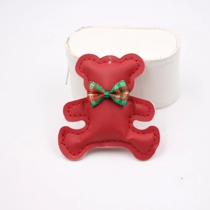 Detail of red leather bear charm with a plaid bowknot for DIY phone case accessories